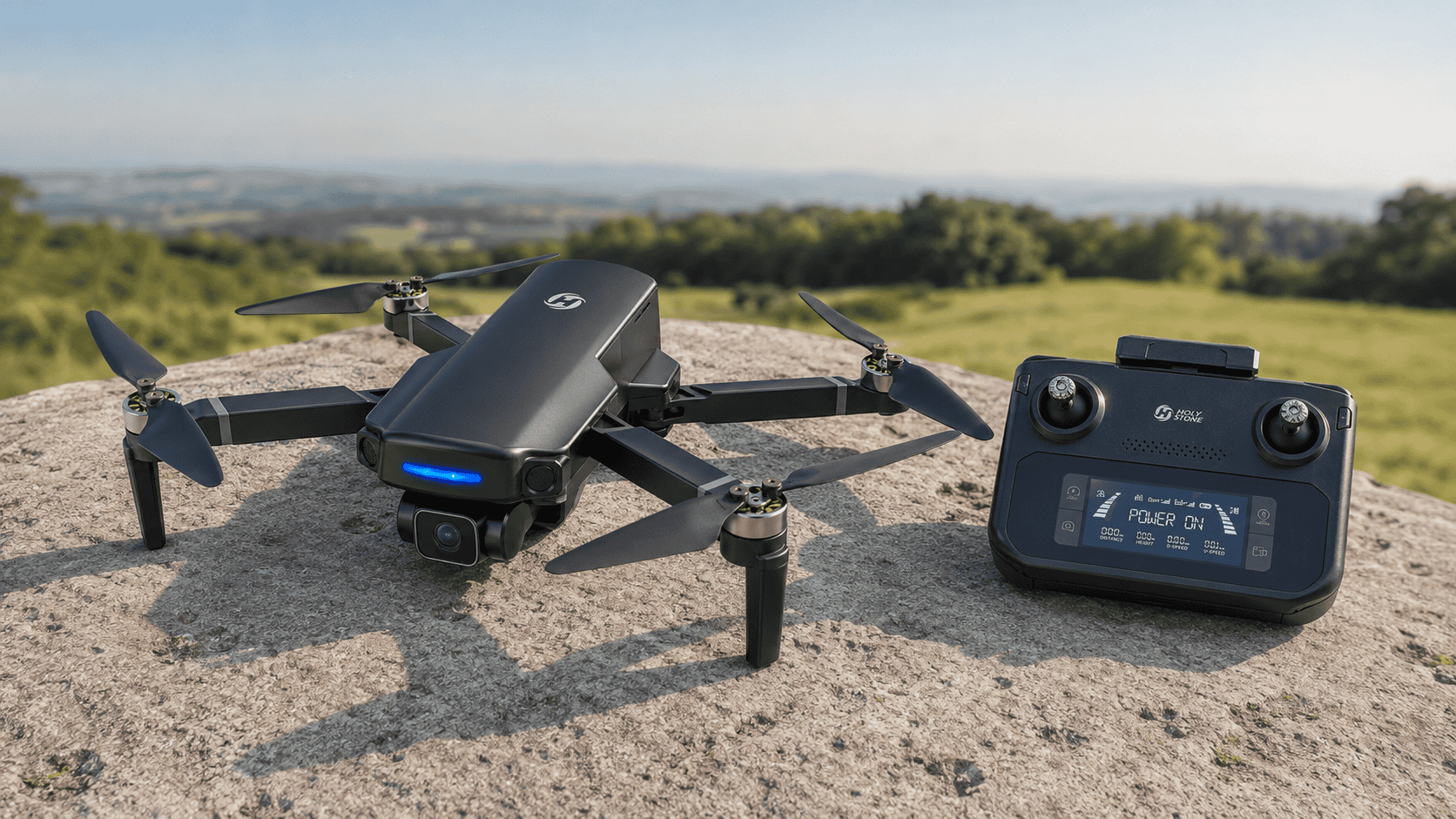 Holy Stone HS360S GPS drone and controller on a stone launch surface overlooking a green field