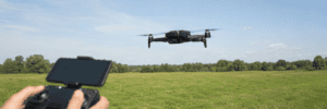 Black Holy Stone HS360S flying over an open grassy field.